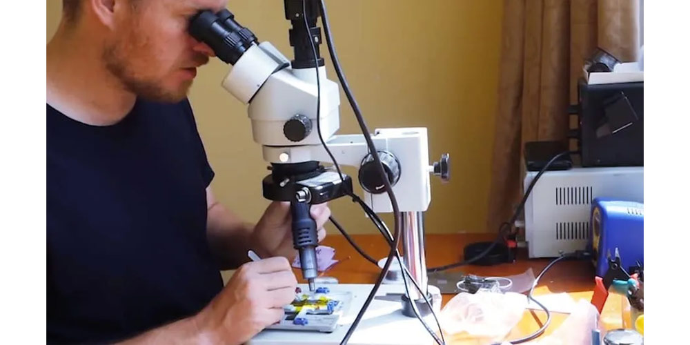 تکنسین برای تعمیر هارد آیفون 6 از میکروسکوپ استفاده می کند