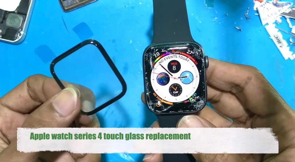 گلس ساعت هوشمند اپل واچ 4 44 میلیمتری در یک دست و اپل واچ در دست دیگر قرار دارد و گلس شکسته است