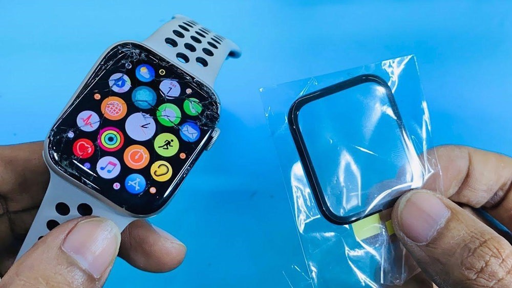 گلس ال سی دی اپل واچ 5 مدل 44 میلیمتری در کنار ساعت هوشمند که گلس آن شکسته است قرار دارد