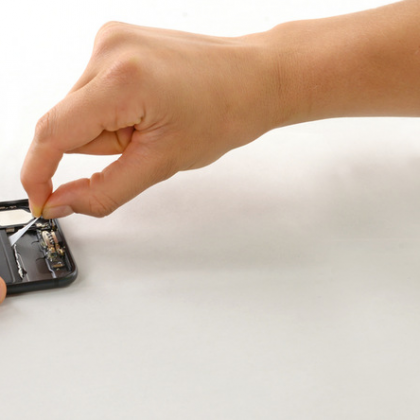 زبانه های چسب نگهدارنده باتری را از لبه پایین بردارید