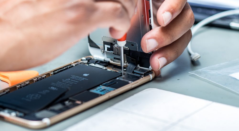 مرد در حال تعمیر موبایل اپل است