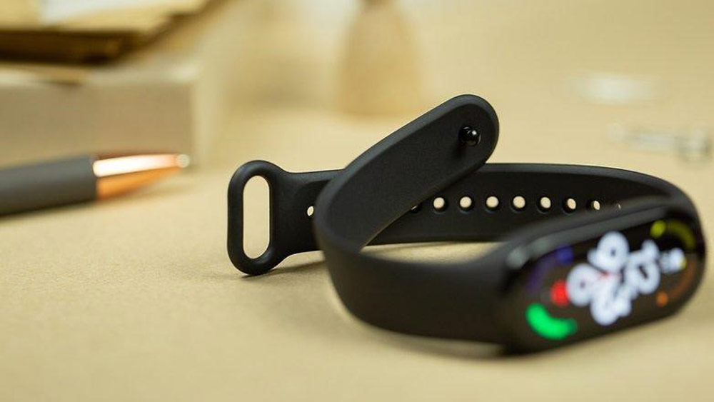 متن الت: نمای Smart Band 7 که روی یک میز دراز کشیده است