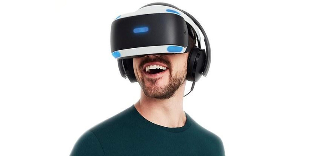 هدفون گیمینگ سونی GOLD PS4 روی سر کاربر قرار دارد و مرد با عینک VR بازی می کند