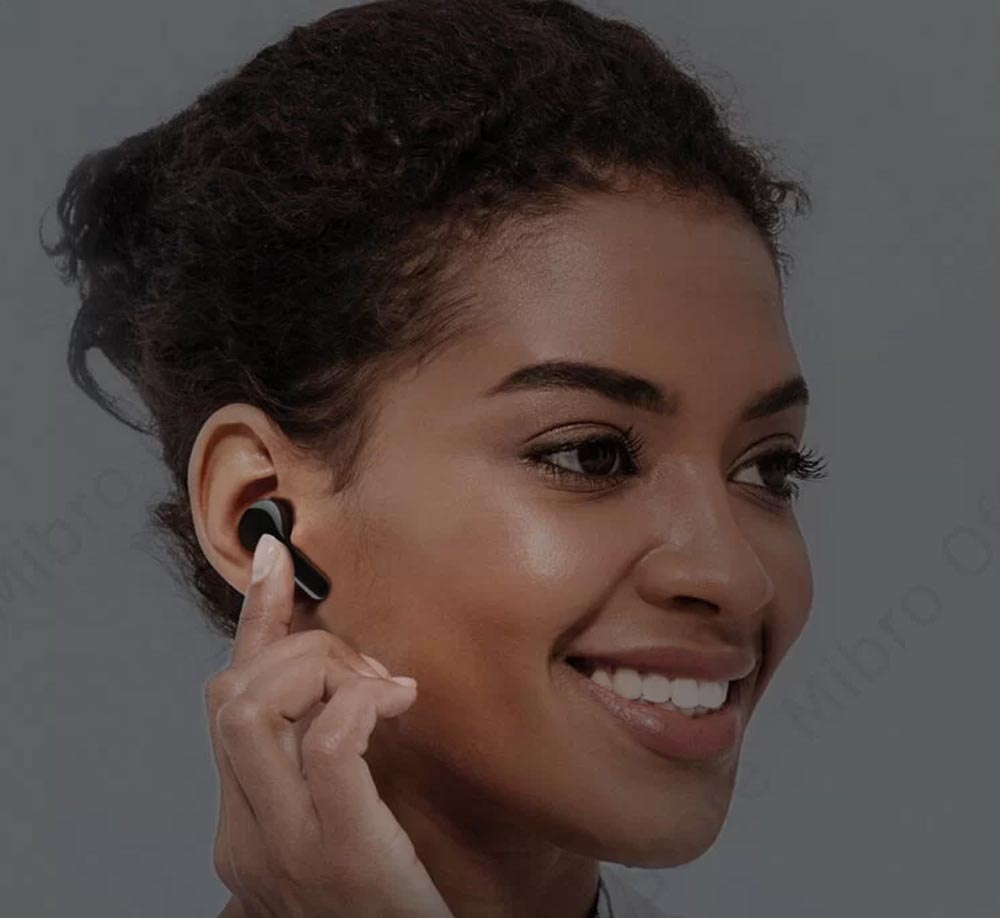 هندزفری mibro earbuds 3 pro در گوش زن است و در حال کنترل آن می باشد