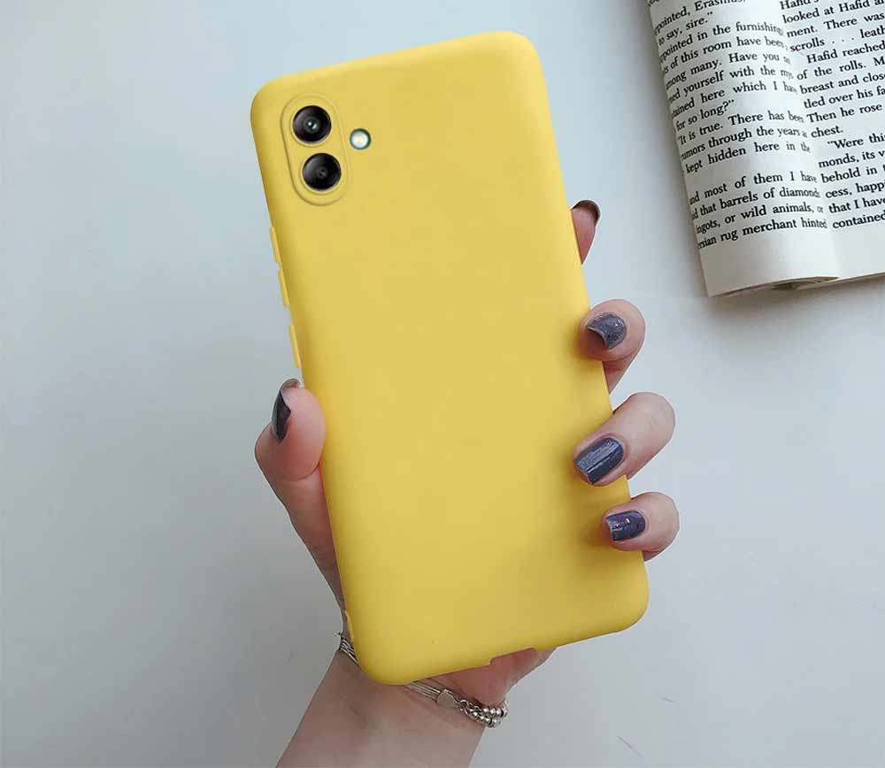 کاور گوشی سامسونگ Galaxy A05 مدل سیلیکونی محافظ لنزدار روی گوشی نصب شده و در دست زن دیده می شود